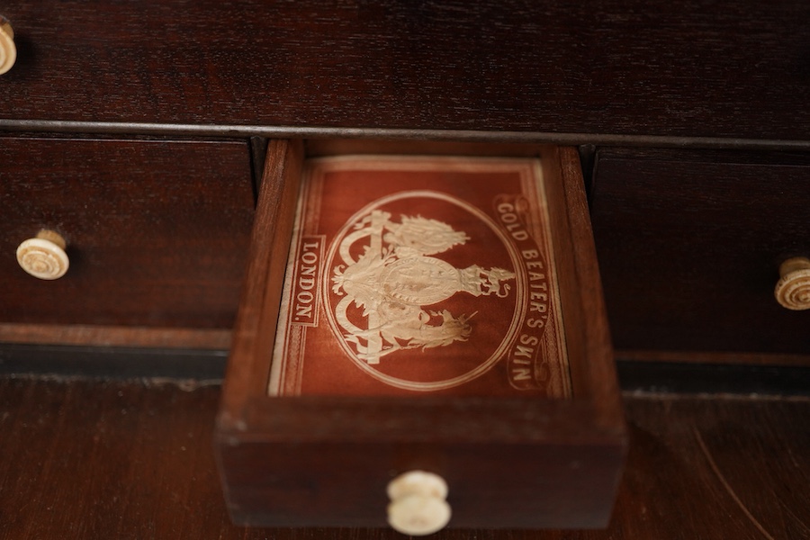 A 19th century mahogany apothecary cabinet, interior with fitting compartments containing twenty-one glass bottles, most with stoppers, five drawers with ivory knobs containing a miniature pestle and water, mixing glasse